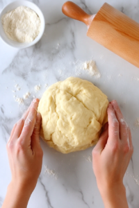 This image shows dough being kneaded on a clean surface, working it into a smooth and firm texture for the soul cakes.