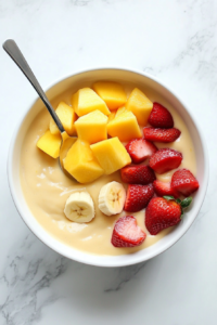 This image shows chopped fruits being stirred into the creamy custard to create a colorful, delicious mixture.