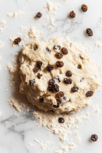 This image shows raisins being added to the dough, infusing the soul cakes with a burst of sweet fruit flavor.