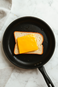 placing-the-buttered-bread-and-cheese-in-the-skillet-to-melt-perfectly