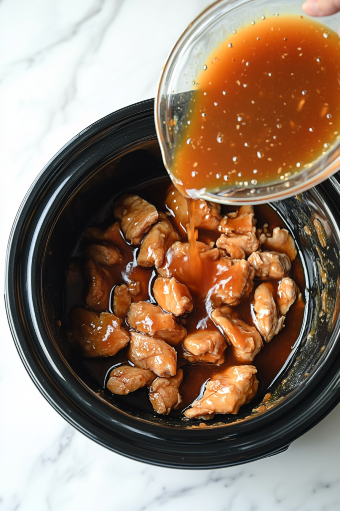 pouring-orange-sauce-over-chicken-in-the-slow-cooker-1096370-683x1024