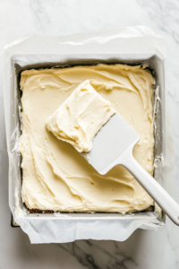 pouring-the-creamy-topping-over-the-cake-batter-base-2