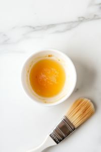 This image shows a small bowl filled with a whisked egg wash, ready to be brushed onto the pastry for a golden finish.