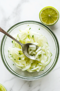 This image shows a bowl with finely chopped onions being mixed, preparing the flavorful onion base for the shrimp cocktail.