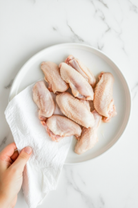 This image shows freshly fried wings resting on a wire rack, allowing excess oil to drain for a crispier texture.