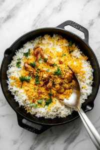 This image shows the Chicken Dum Biryani resting after cooking, allowing the flavors to meld before being gently fluffed to reveal perfectly separate and aromatic rice grains.