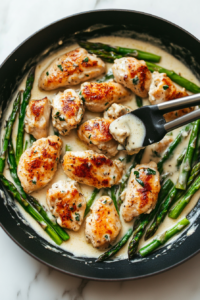 This image shows the cooked chicken being placed back into the skillet, allowing it to soak up the creamy sauce.