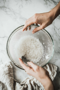 This image shows a close-up of Calrose rice being rinsed in a bowl, an essential step to remove excess starch before cooking in the Instant Pot.