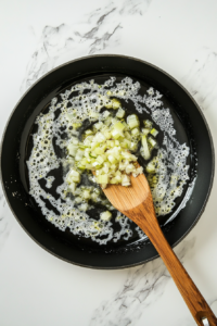 sauteing-onion-and-celery-in-a-skillet-to-build-flavor-for-stuffing-balls