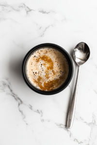 This image shows a saucepan on the stovetop with vinegar, sugar, and spices gently simmering to create the perfect brine for preserving cucumbers and onions in sweet pickles.