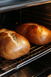 This image shows sweet Amish bread loaves baking in the oven, turning golden brown with a soft, perfectly baked texture.