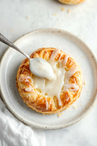 sweet-vanilla-glaze-being-gently-drizzled-over-freshly-baked-cheese-danish-2