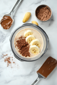 adding-ingredients-to-blender-for-chocolate-peanut-butter-smoothie-top-down-view