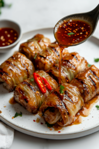 drizzling-savory-sauce-over-grilled-cabbage-rolls