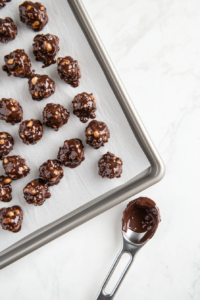dropping-spoonfuls-of-chocolate-peanut-butter-mixture-onto-baking-sheet-top-down-view