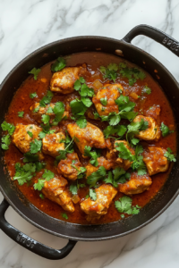 This image shows the final Chicken Karahi dish garnished with fresh cilantro and a sprinkle of garam masala. The dish rests for a few minutes, allowing the flavors to deepen before serving.
