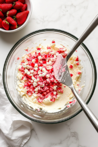 gently-folding-chopped-strawberries-into-pound-cake-batter-before-baking