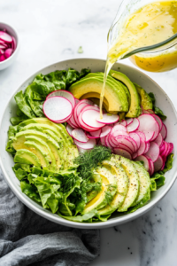 This image shows the avocado salmon salad being assembled, with creamy avocado, crisp radishes, and flaky salmon coming together in a perfect harmony.