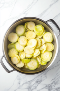 This image shows butter melting in a pot with freshly chopped leeks being added, beginning the base for the soup.