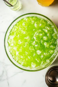 This image shows Hawaiian Punch being mixed with grapefruit soda in a large bowl, creating a fizzy and flavorful base for the Potion Punch. The carbonation adds a refreshing, bubbly effect.