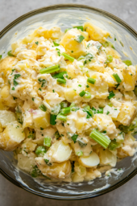 This image shows a bowl of No Onion Potato Salad resting in the fridge, allowing the flavors to meld before serving.