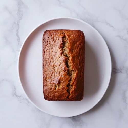 salty-marshmallows-banana-bread-loaf-golden-brown-perfectly-baked-on-round-white-plate