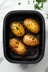 This image shows well-seasoned potatoes placed inside the air fryer basket, spaced evenly to allow for proper air circulation and even cooking.