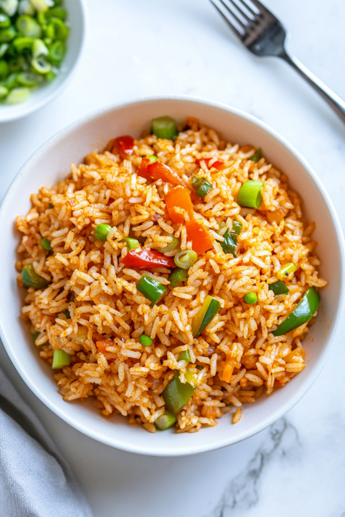 This image shows the finished Cajun rice being served in a bowl, ready to be enjoyed with its colorful, flavorful mix of rice and veggies.