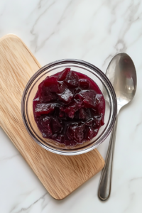 This image shows a small bowl of kokum or tamarind soaking in water, slowly releasing its deep reddish-brown color. The liquid takes on a slightly thick texture, essential for achieving the signature tangy flavor of Kerala Fish Curry.