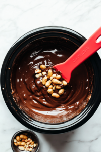 stirring-melted-chocolate-peanut-butter-and-nuts-for-even-consistency-top-down-view