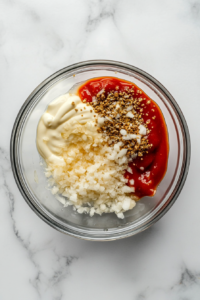 adding-finely-minced-onion-garlic-and-a-splash-of-vinegar-into-burger-sauce-mixture