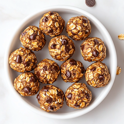 This image shows a close-up view of freshly rolled lactation energy balls, made with a wholesome blend of creamy peanut butter, golden honey, fragrant vanilla extract, and hearty oats.