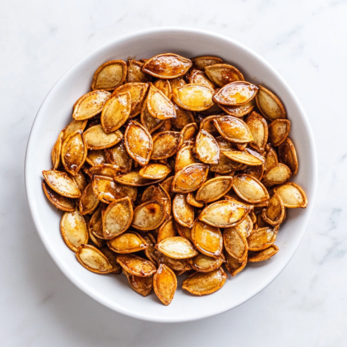 honey-roasted-pumpkin-seeds-in-a-round-white-bowl-sprinkled-with-white-sugar