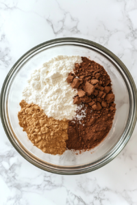 This image shows a mixing bowl filled with flour, sugar, and dry ingredients being whisked together to start the cinnamon roll dough.