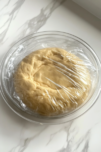 a-small-bowl-filled-with-brown-sugar-and-cinnamon-being-mixed-with-a-spoon-for-the-roll-filling