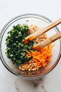 adding-fresh-vegetables-and-crushed-peanuts-to-noodles