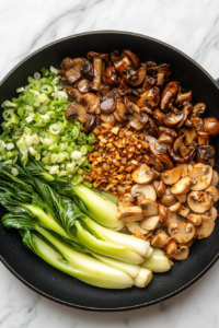 adding-hearty-mushrooms-and-bok-choy-to-the-pan