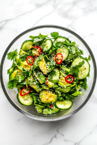 This image shows the finished Asian Avocado Salad served immediately, vibrant and fresh with bright greens, creamy avocado, and pops of red chili.