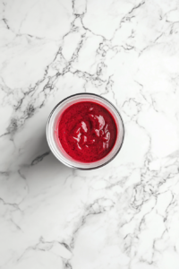 This image shows strawberry sauce being pureed to a smooth consistency before being refrigerated for later use.