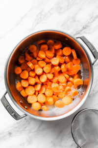 his image shows dry ingredients being sifted into a mixing bowl, ensuring a light and airy texture for the carrot soufflé batter.