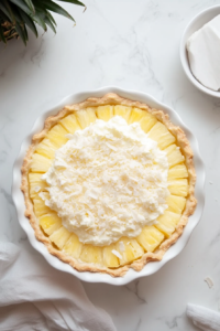 This image shows a chilled slice of pina colada pie being served, revealing layers of pineapple, creamy coconut filling, and a crisp golden crust.