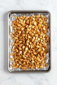coated-pumpkin-seeds-evenly-spread-on-parchment-lined-baking-sheet