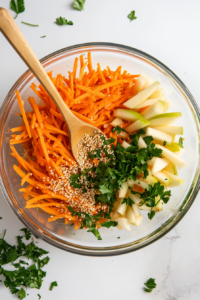 combining-julienned-carrots-and-apples-in-a-mixing-bowl-for-the-salad-base-top-down-shot