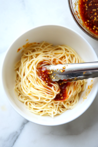 combining-noodles-and-sauce-until-every-strand-is-coated