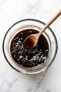 This image shows wet and dry ingredients being combined in a mixing bowl, forming a thick and luscious batter ready for baking.