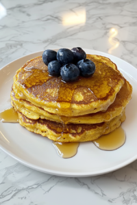 This image shows multiple pancakes being cooked from the remaining batter, all evenly golden and fluffy.