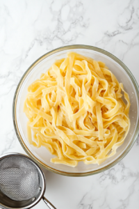 draining-cooked-pasta-in-a-colander-over-the-sink