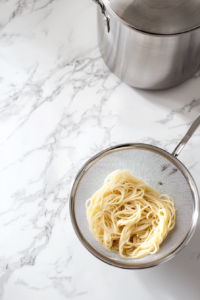 draining-freshly-cooked-noodles-using-strainer