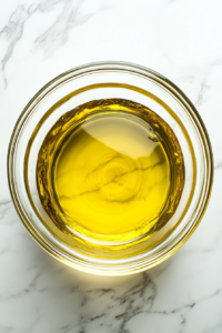 This image shows sifted flour, cocoa powder, and baking powder being mixed into the egg yolk mixture in a clear glass bowl over a white marble surface.