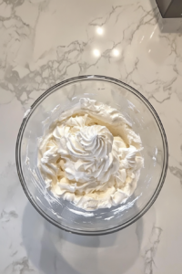 fluffy-whipped-cream-piled-high-in-a-bowl-for-layering-into-banana-pudding-trifle